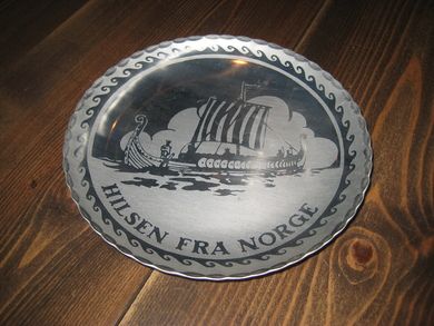 Rundt fat med bilde av vikingskip. Ca 19 cm i diameter.