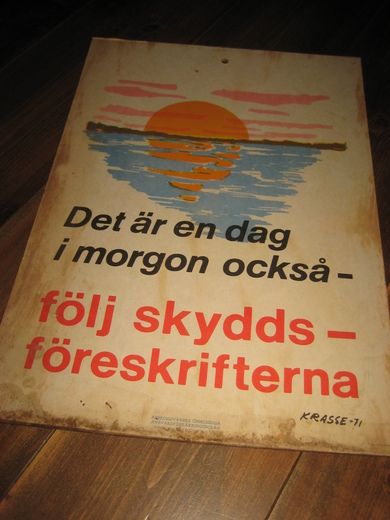 Plakat på plate, ca 35*50 cm stor, Det er en dag i morgen också- følj skyddsføreskriften. KRASSE-1971.