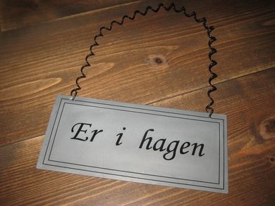 Blikkskilt med tekst: Er i hagen.